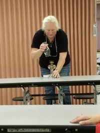 Adult demonstrating an old lamp (2nd Grade Pioneer Day - Fall 2017)