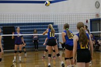 Volleyball player bumping the volleyball over the net