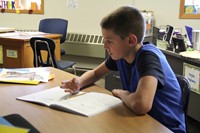A boy working on a math booklet