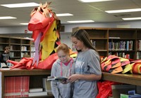 Two girls looking at a book in the library