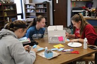 Three girls working on a craft project