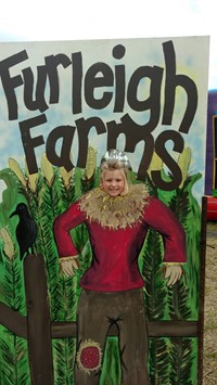 student in a scarecrow photo display