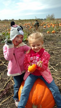 students sitting on a pumpkin