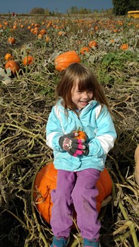 student sitting on a pumpkin