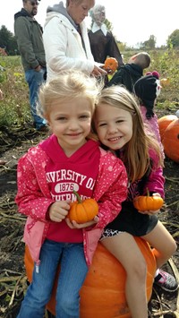 students sitting on a pumpkin