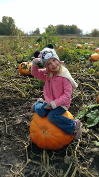 student sitting on a pumpkin