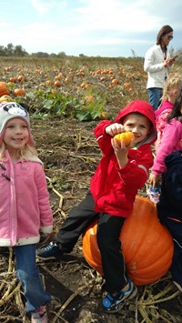 student sitting on a pumpkin