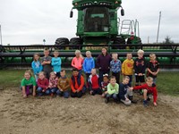 GHV First Grade Students visiting farm with a combine nearby