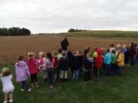 GHV First grade students visiting farm and standing near field to be harvested
