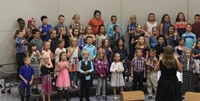 Second grade students standing on risers and singing