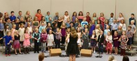Second grade students standing on risers and singing