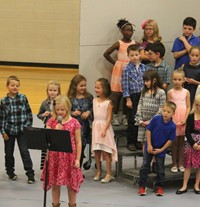 Second grade students standing on risers and singing