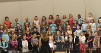 Second grade students standing on risers and singing