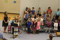 Second grade students standing on risers and singing