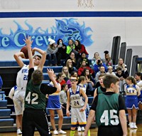 A boy going up for a shot in a basketball game