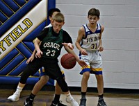 Two basketball players guarding an opposing player