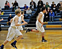 Three basketball players running up the court
