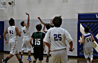 A group of boys playing in a basketball game