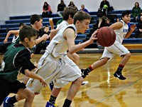 A group of basketball players with one dribbling up the court