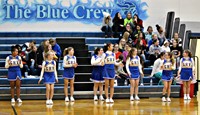 A group of cheerleaders cheering at a basketball game