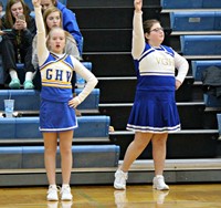 Two cheerleaders cheering during a basketball game