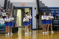 A group of cheerleaders cheering during a basketball game