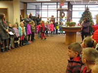 Elementary students singing Christmas carols at the local bank