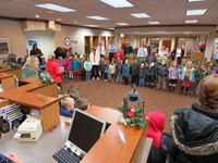 Elementary students singing Christmas carols at the local bank