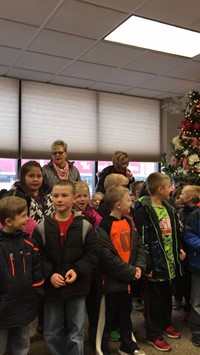 Students singing by a Christmas tree