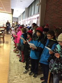 Students standing in a line singing Christmas carols