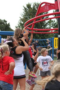 High school students playing with elementary students on playground