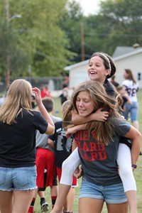 High school students playing with elementary students on playground