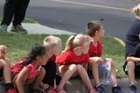 Students sitting on curb waiting for parade