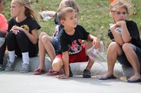 Students sitting on curb waiting for parade