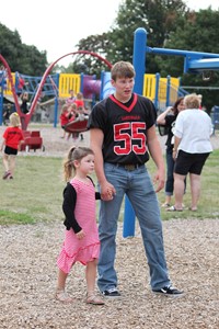 High school student playing with elementary student on playground