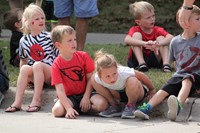 Students sitting on curb waiting for parade