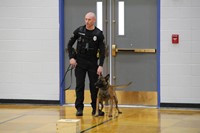 A police officer getting his dog ready to run through his training
