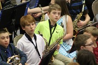 Three intermediate boys getting ready to play in a band concert