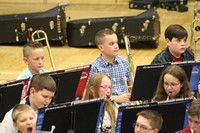 A group of intermediate school students performing in a band concert