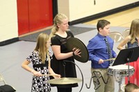 Three students playing percussion during an intermediate band concert