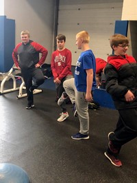 A group of boys balancing on one leg at a career day