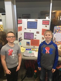 Elementary students standing near their invention, the Foil E +R